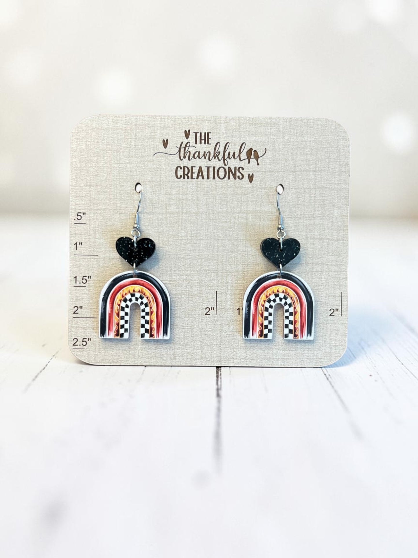 racing arch earrings with checkered flag pattern and flames, black glitter heart acrylic dangle earrings, handmade lightweight race day jewelry