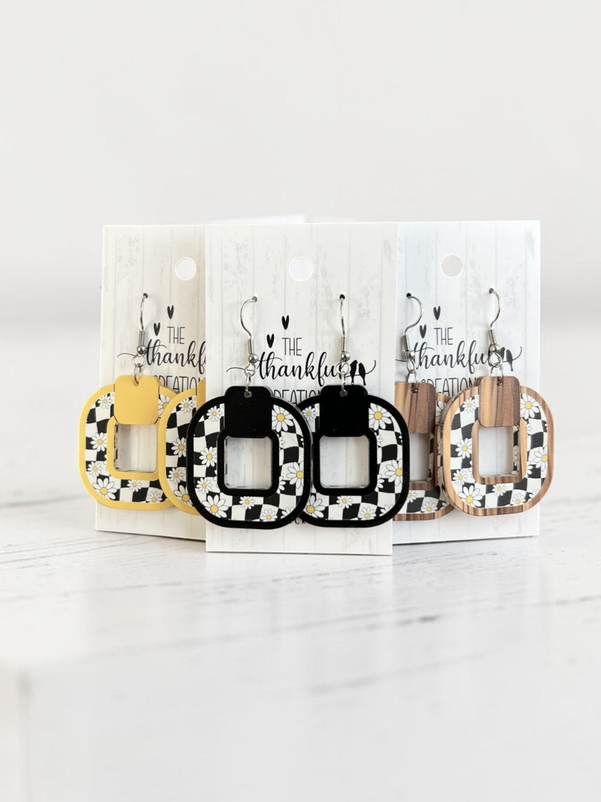 Trendy black and white checkered daisy statement earrings worn as bold everyday jewelry