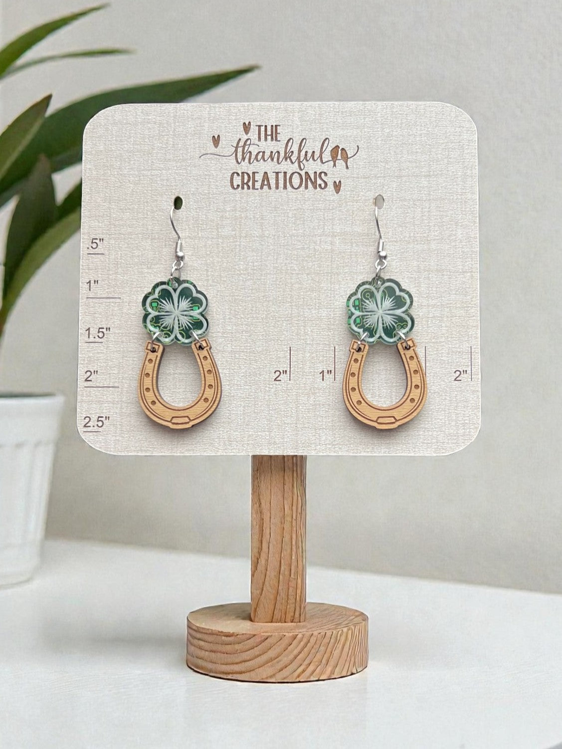 Pair of earrings on a display card with 'The Thankful Creations' branding.