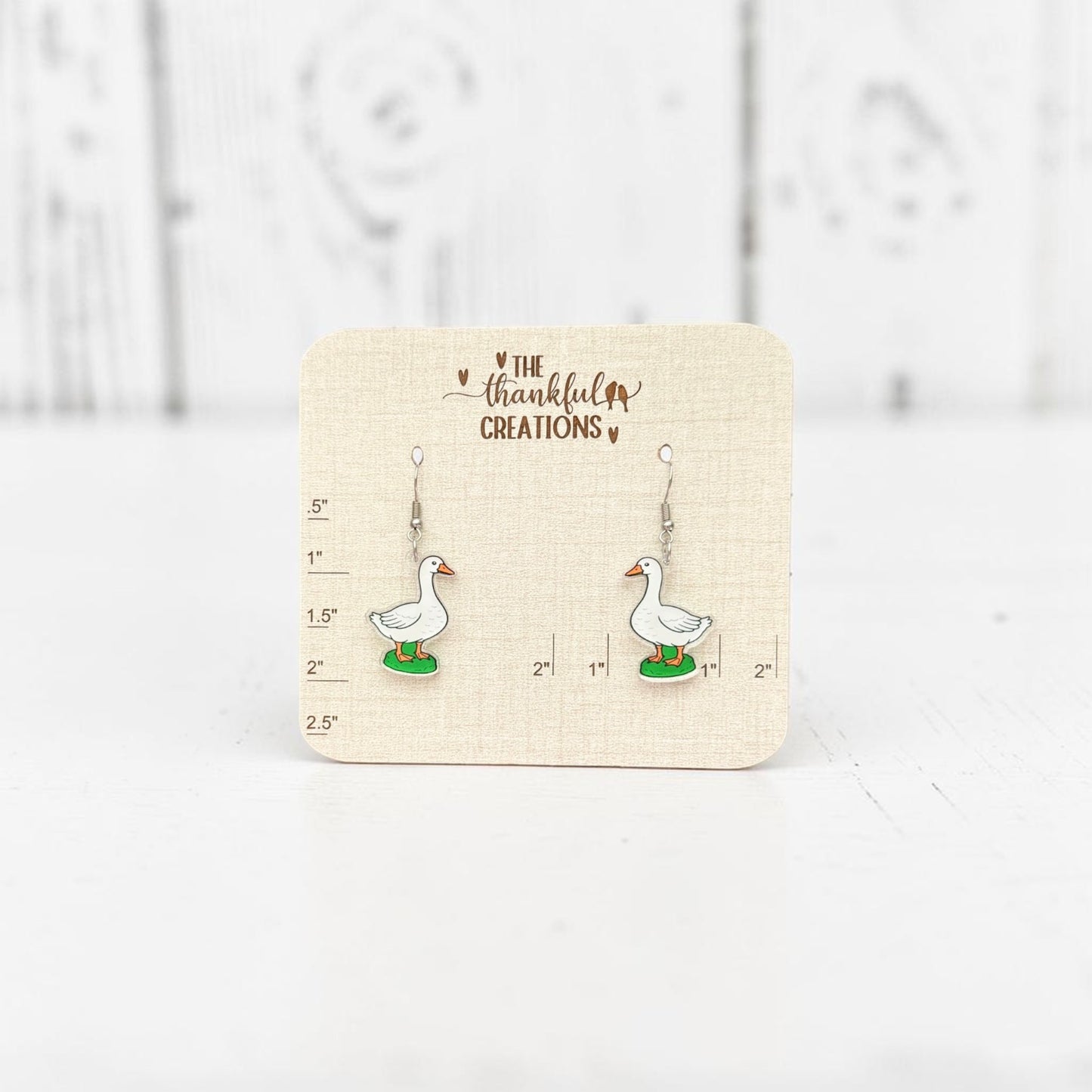 White porch goose acrylic dangle earrings on clear acrylic with stainless steel hooks, cottagecore farmhouse inspired handmade jewelry by The Thankful Creations.