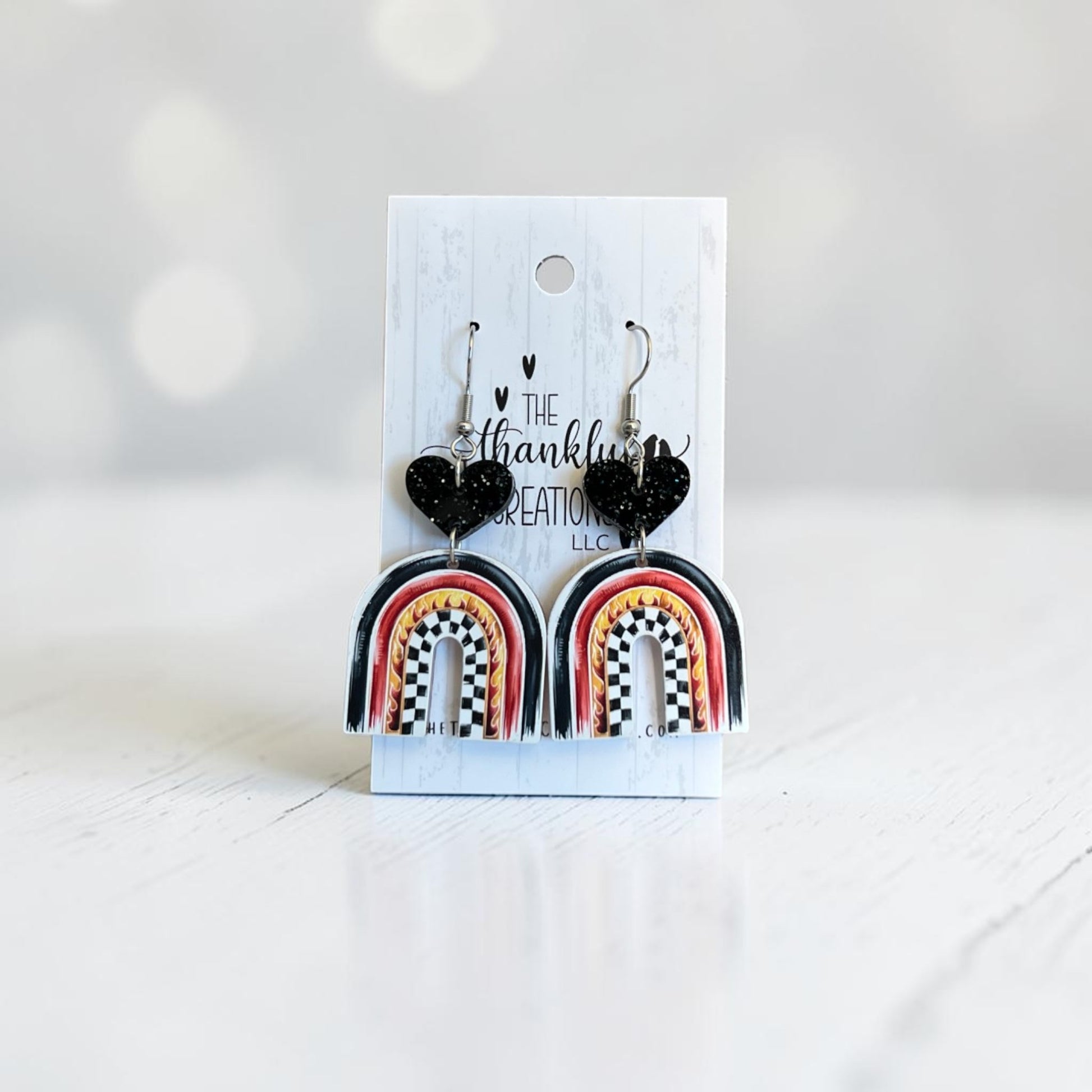 racing arch earrings with checkered flag pattern and flames, black glitter heart acrylic dangle earrings, handmade lightweight race day jewelry